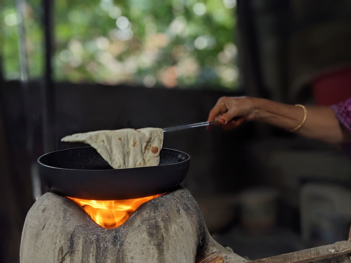 Thin Lebanese flatbread cooking on a hot convex saj griddle over an open flame
